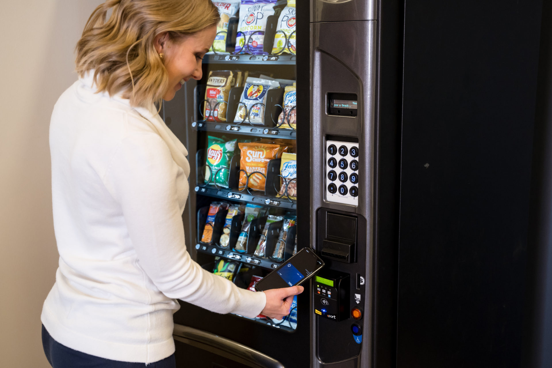 Woman shops at vending machine with her credit card.