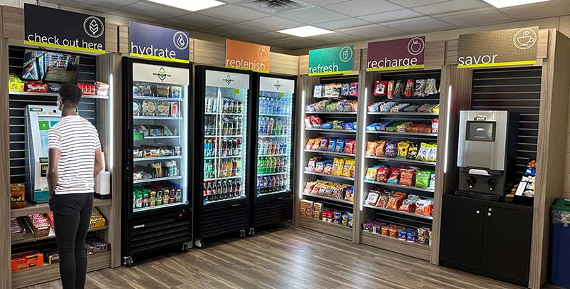 A fully stocked market with coolers and snack racks by Monumental Markets.