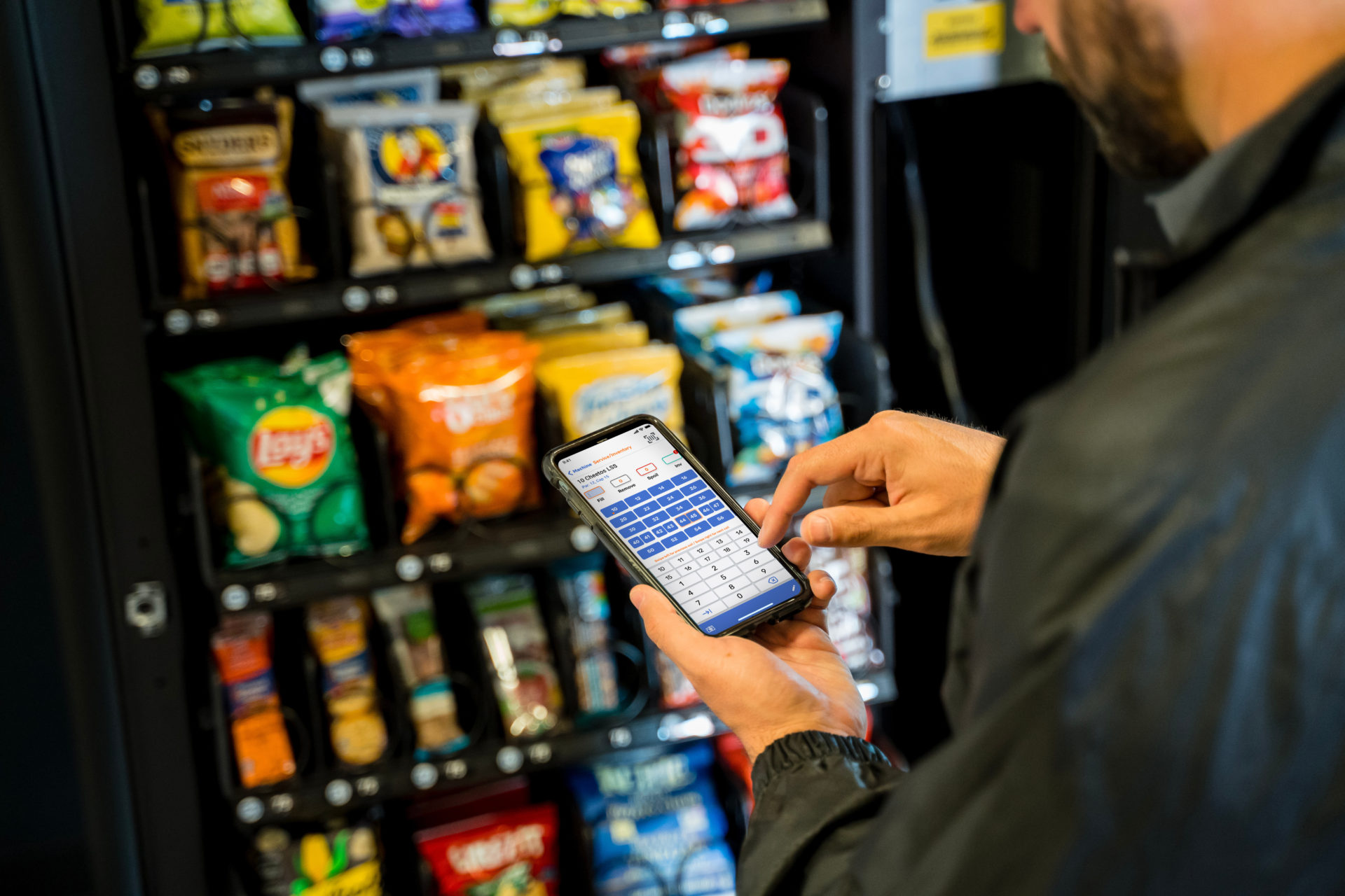 Driver using Seed Driver app to reload vending machine inventory.