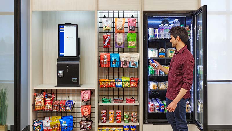 Customer looks at product at a small micro market laid out with snacks and beverages.